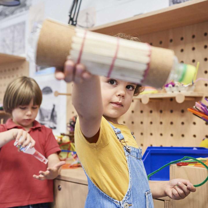 Two children are standing at a workbench.